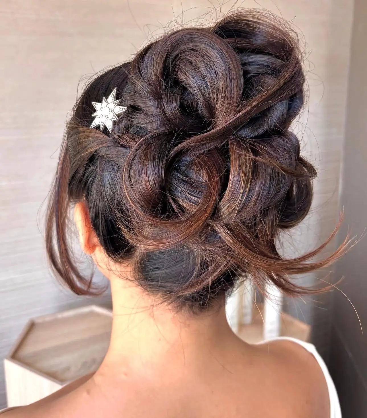 Sculptural brunette updo with a jeweled hairpiece