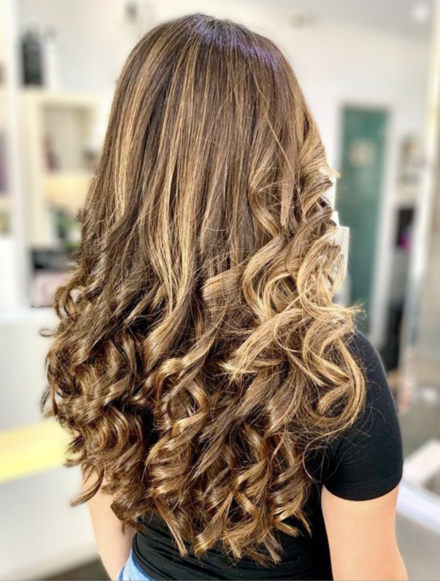 Bouncy caramel highlighted curls styled in the salon