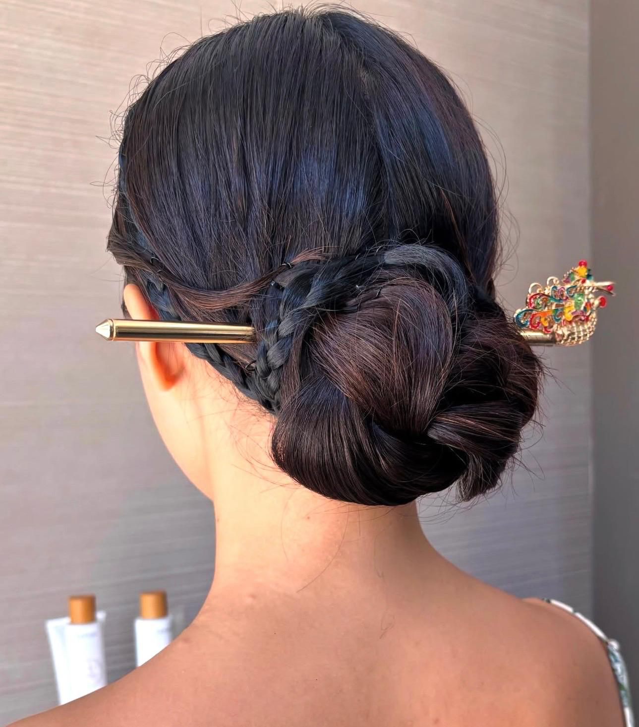 Braided low chignon finished with an ornamental hairpin